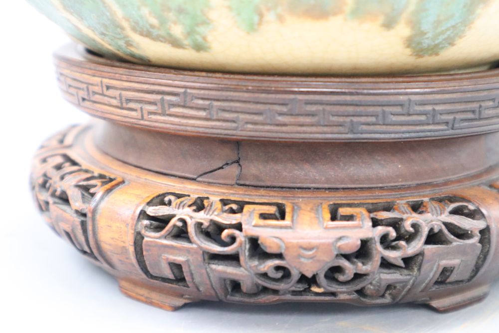 A Chinese green and straw-coloured crackle glaze brushwasher, Qing dynasty hongmu stand, height 13cm overall